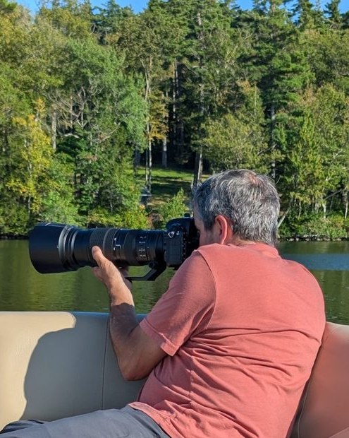 Chris Austermann photographing the lake from a boat